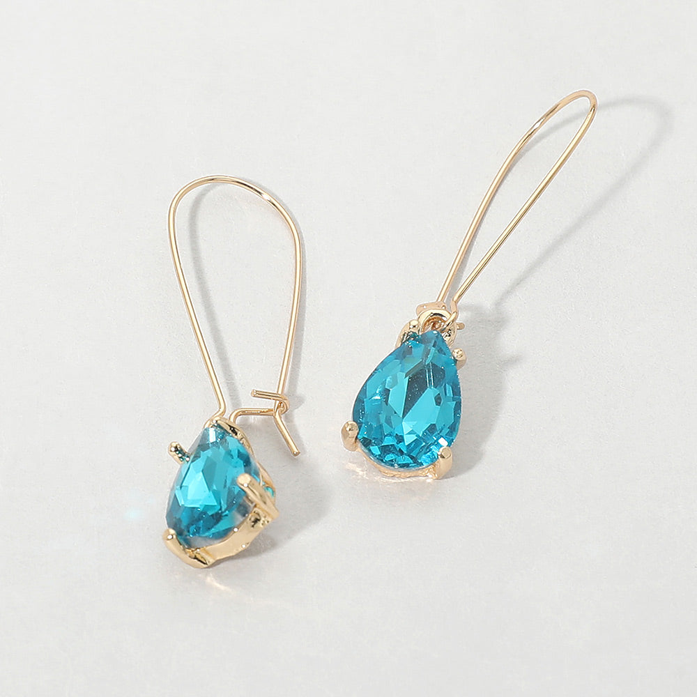 Elegant teal teardrop dangle pageant earrings on gold on white background