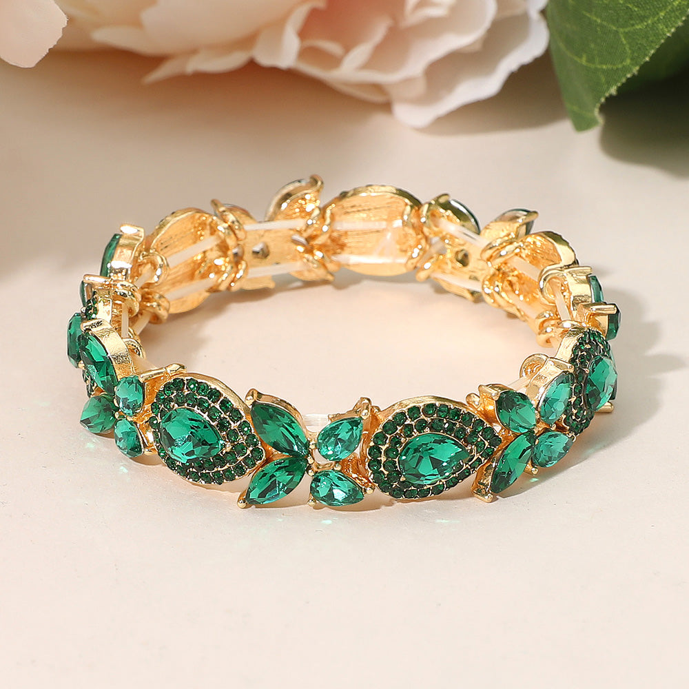 Emerald green marquise rhinestone stretch bracelet on gold for pageants or formal occasions on a peach background