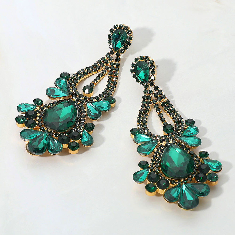 Emerald green teardrop chandelier statement earrings for prom or pageant wear on a light background