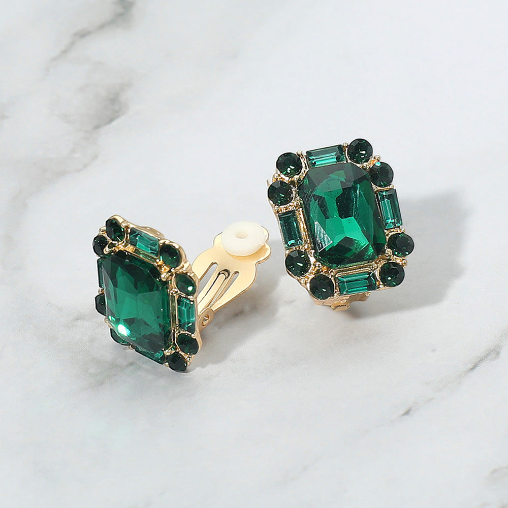 Emerald Cut Green-Emerald Stone Clip On Earrings gold backed on a grey and white granite background