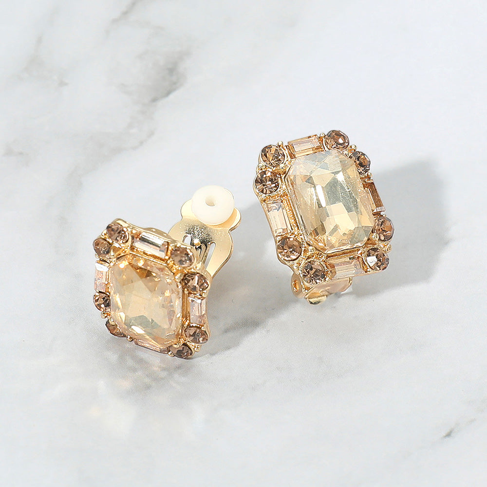 Emerald Cut Light Topaz Stone Clip On Earrings gold backed on a grey and white granite background
