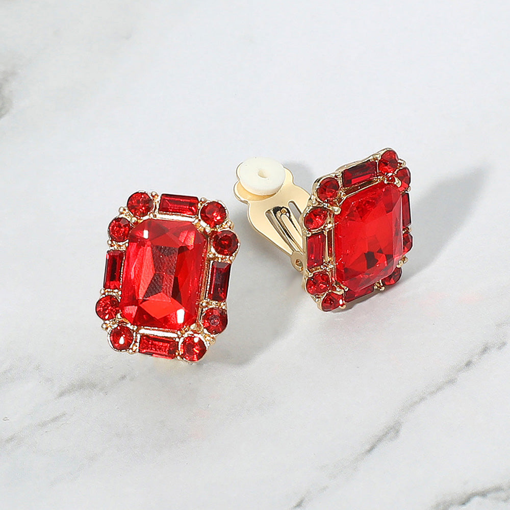Emerald Cut Red Stone Clip On Earrings gold backed on a grey and white granite background