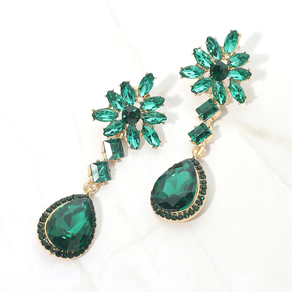Emerald green crystal flower teardrop earrings in a gold finish featuring marquise crystal flower tops and large faceted emerald green teardrop drops, displayed on a white background.