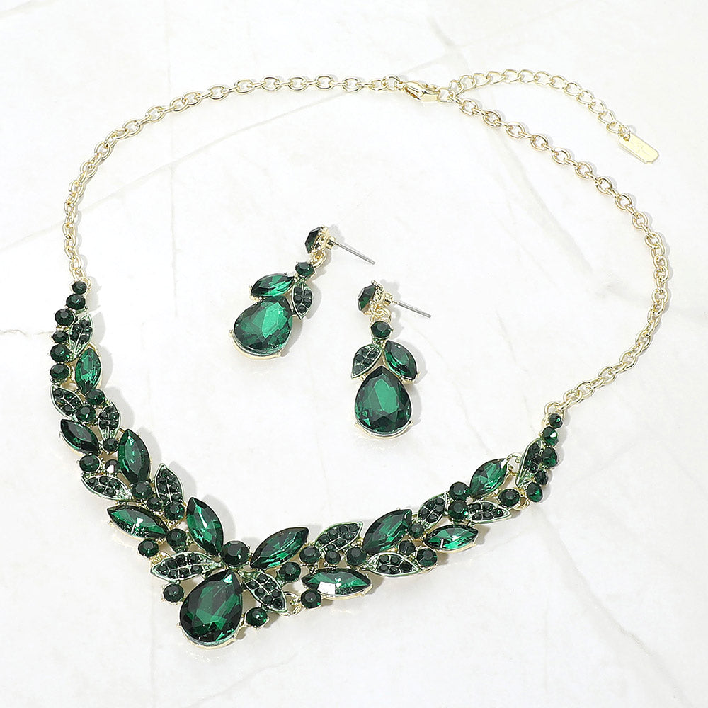 Emerald Green teardrop and marquise crystal jewelry set on gold displayed on white marble background