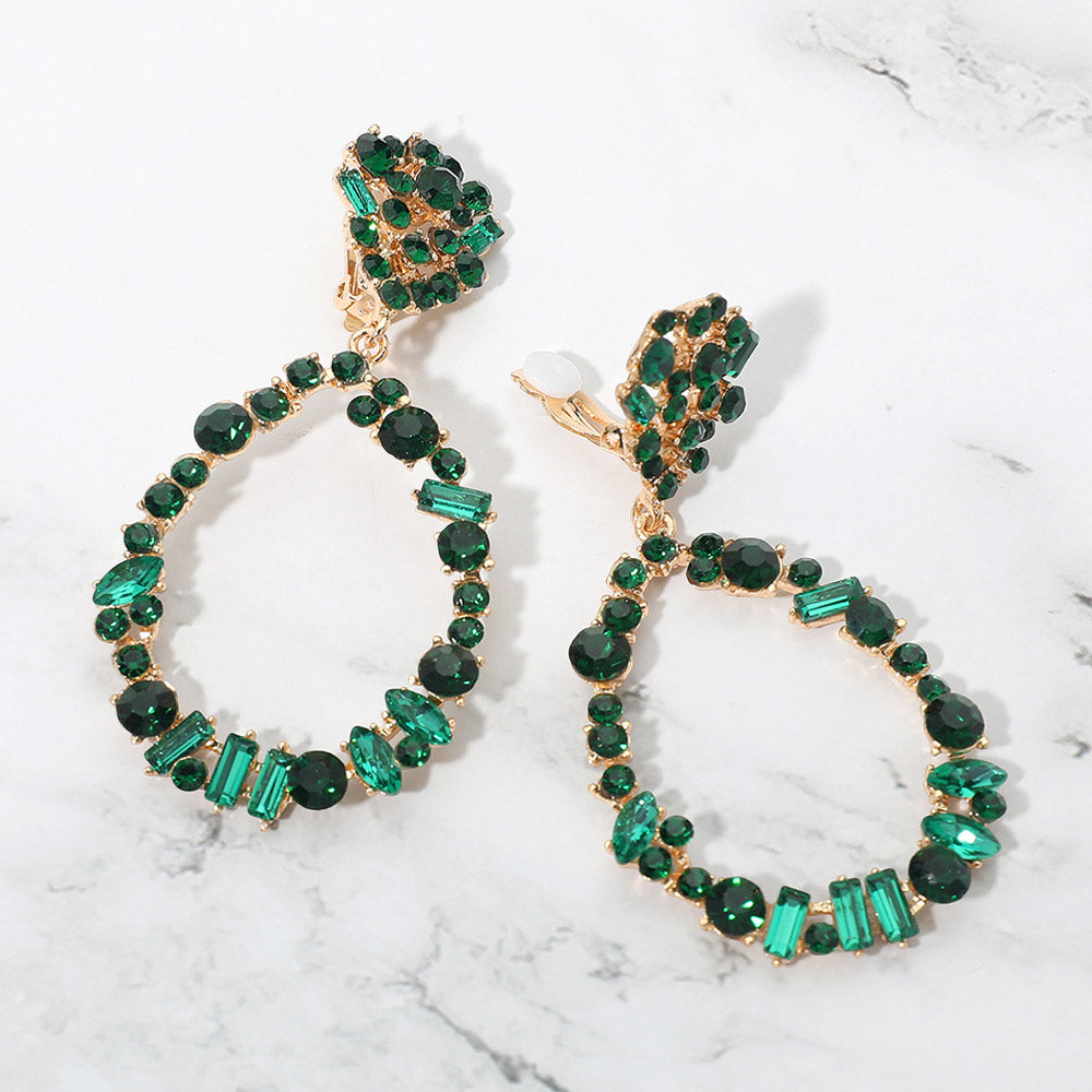 Emerald green mixed stone cluster open teardrop clip-on pageant earrings on gold on a white background