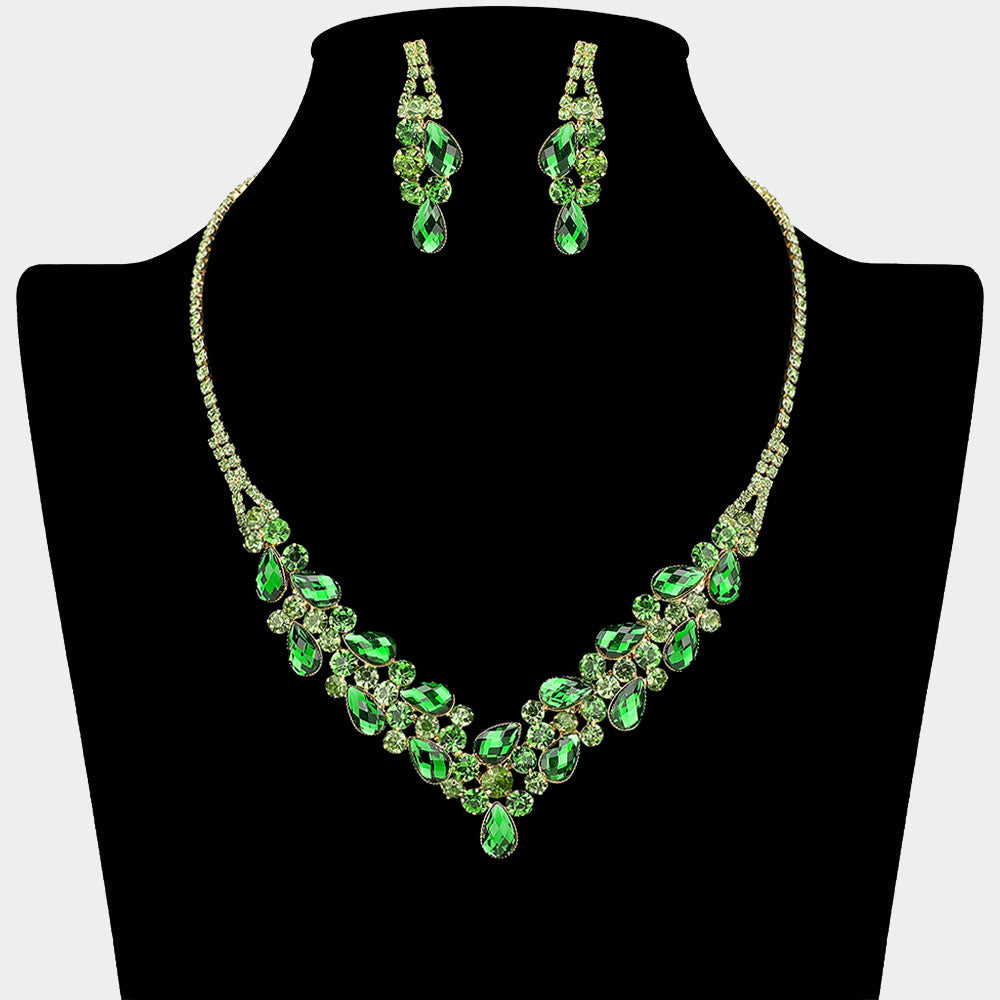 Emerald Green teardrop rhinestone necklace set with V-shaped crystal design and matching earrings, all backed in gold, for prom and formal wear. Shown on a black mannequin bust.  