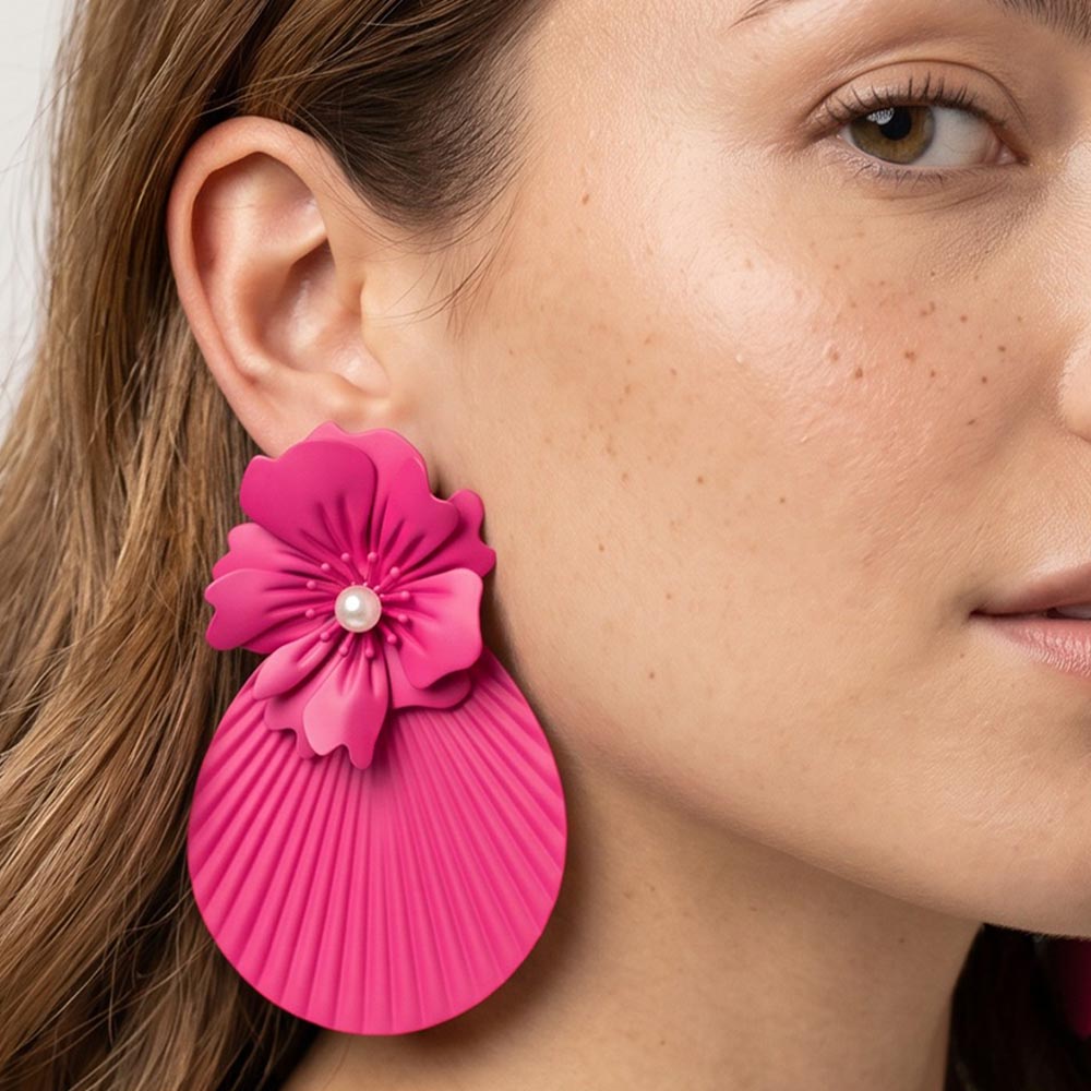 Model wearing oversized hot pink - fuchsia flower fan statement earrings with layered floral tops and pleated fan drops, showing their 4.25-inch length and bold scale.