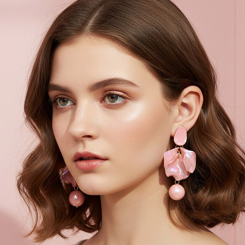 Woman wearing Pink iridescent layered petal statement dangle earrings on gold with reflective multicolor center accents and round pink details.