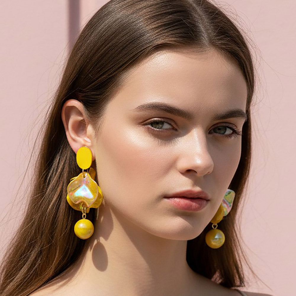 Woman wearing Yellow iridescent layered petal statement earrings on gold with a reflective multicolor center and round yellow accents.