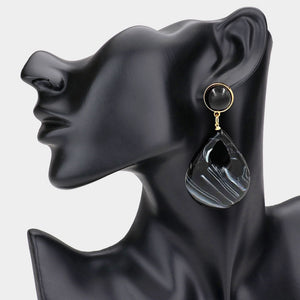 Black resin teardrop cutout dangle earrings on a black mannequin ear on a white background— bold modern 3.25" fashion statement jewelry.