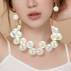 Chunky clear on gold iridescent balls/spheres necklace with matching earrings on the neck of a girl wearing a white shirt