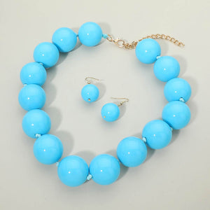 Light Blue chunky ball beaded statement necklace set with oversized round beads and matching drop earrings, displayed on a light cream background.