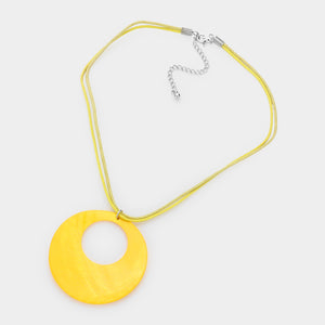 Yellow open-circle necklace on silver with an oversized round pendant displayed on a white background.