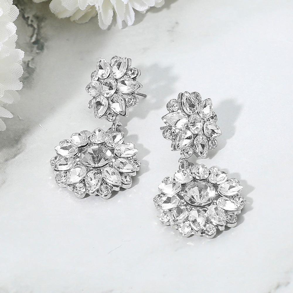 Clear floral stone cluster drop earrings with layered rhinestones for pageants or weddings on a white background