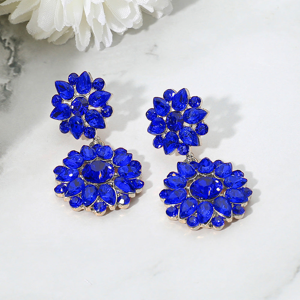 Sapphire floral stone cluster earrings with drop design for prom or pageant on a white background