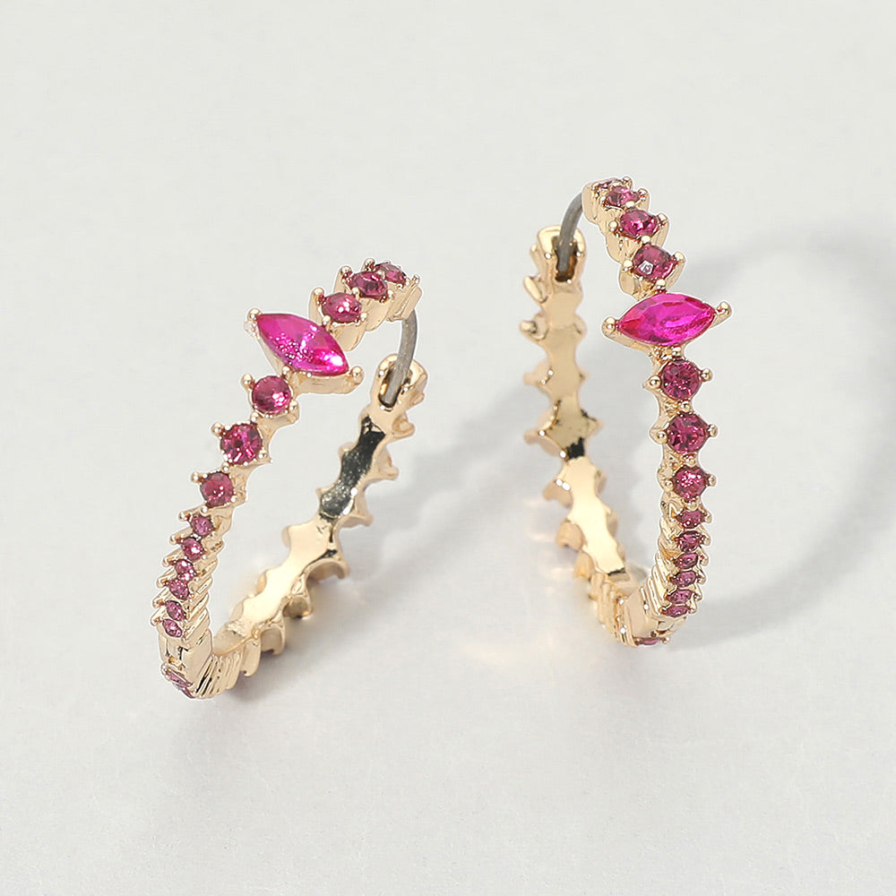 A pair of gold huggie hoop earrings with Fuchsia Hot Pink marquise and round gemstones, displayed on a light gray background.