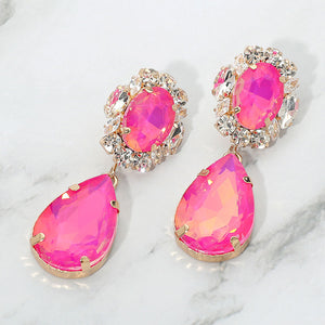 Fuchsia hot pink oval and teardrop earrings with clear crystal accents on gold on a white marble background