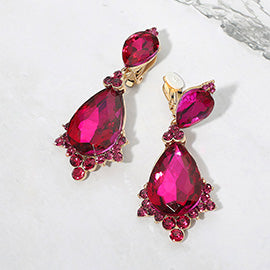Fuchsia hot pink faceted teardrop clip-on statement earrings on gold on a white marble background