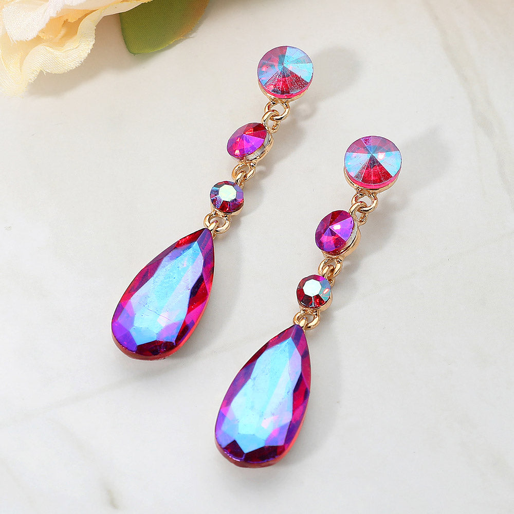 Fuchsia rhinestone multi stone dangle earrings with teardrop crystal for prom or evening wear on a white background