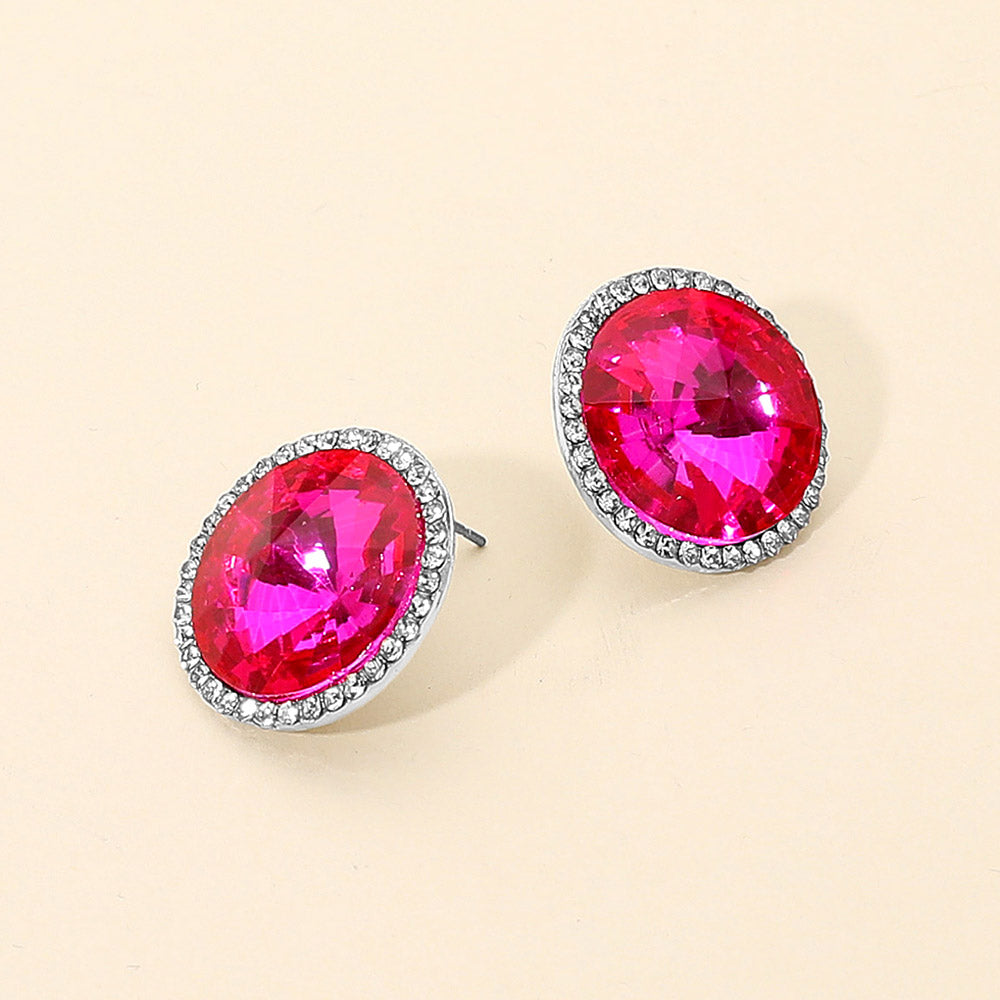 fuchsia-hot pink round center crystal surrounded by clear rhinestones stud earrings on silver post on a white background – elegant statement jewelry for prom or pageant looks