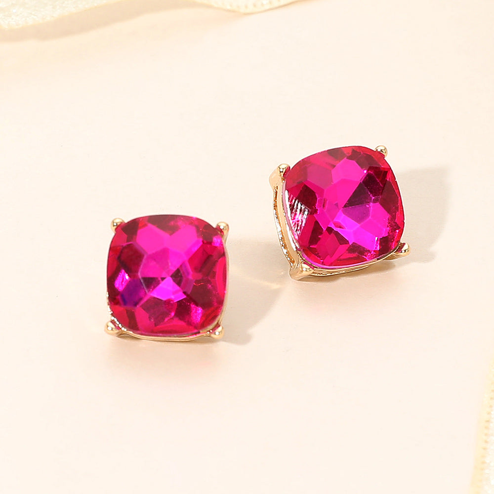 Fuchsia hot pink square cushion stud earrings on gold on light beige background