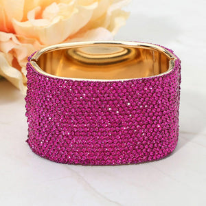 Fuchsia wide rhinestone hinged bangle bracelet with a chunky statement silhouette and polished gold-tone setting