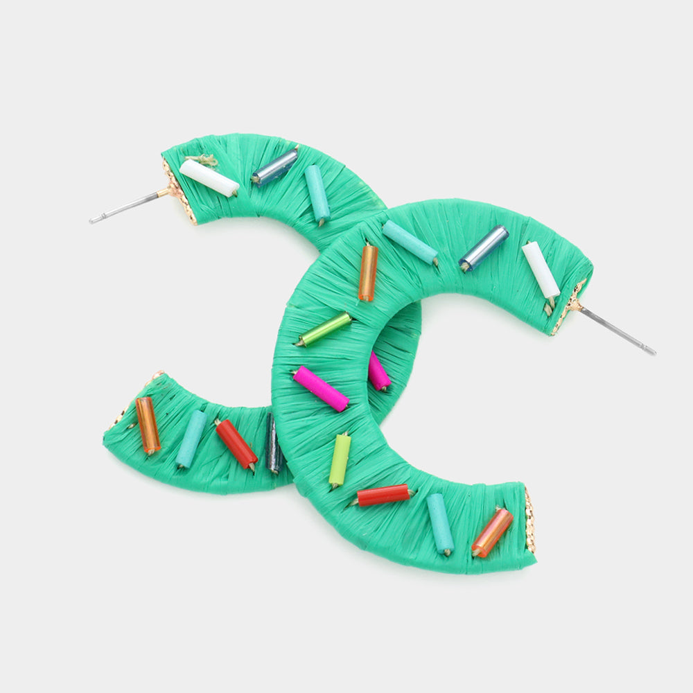 Multi Color Cylinders embellished onto a green raffia wrapped half earring on a white background 1.75"