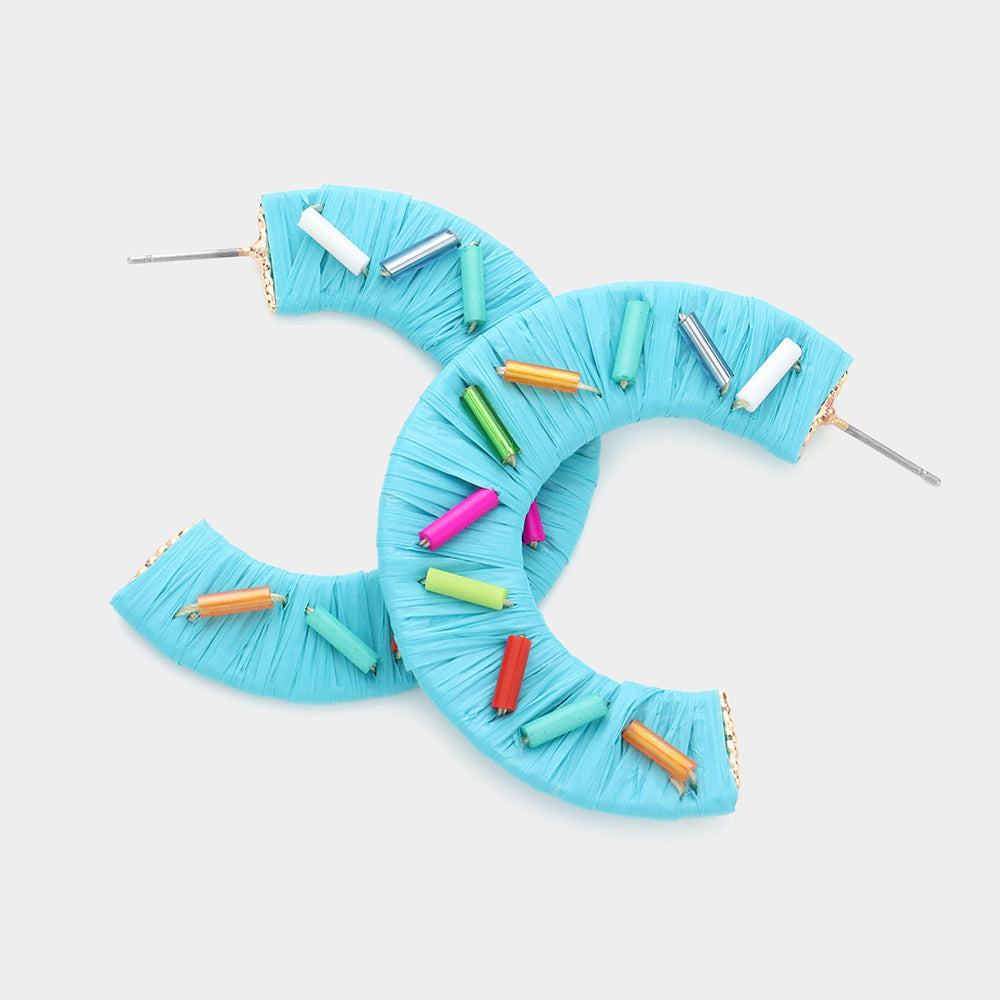 Multi Color Cylinders embellished onto a turquoise raffia wrapped half earring on a white background 1.75"