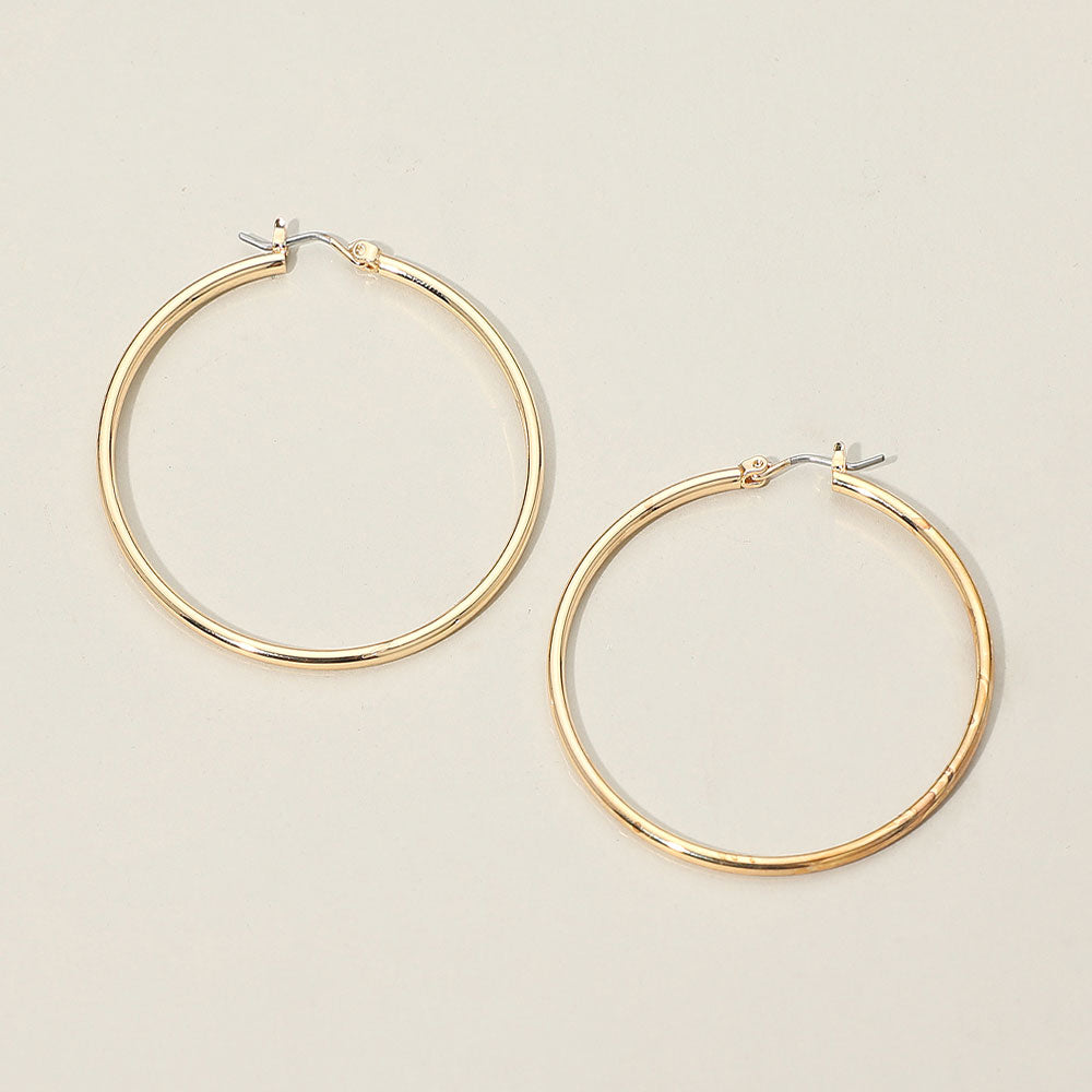 Gold classic hoop earrings with a 2-inch diameter displayed on a light grey background.