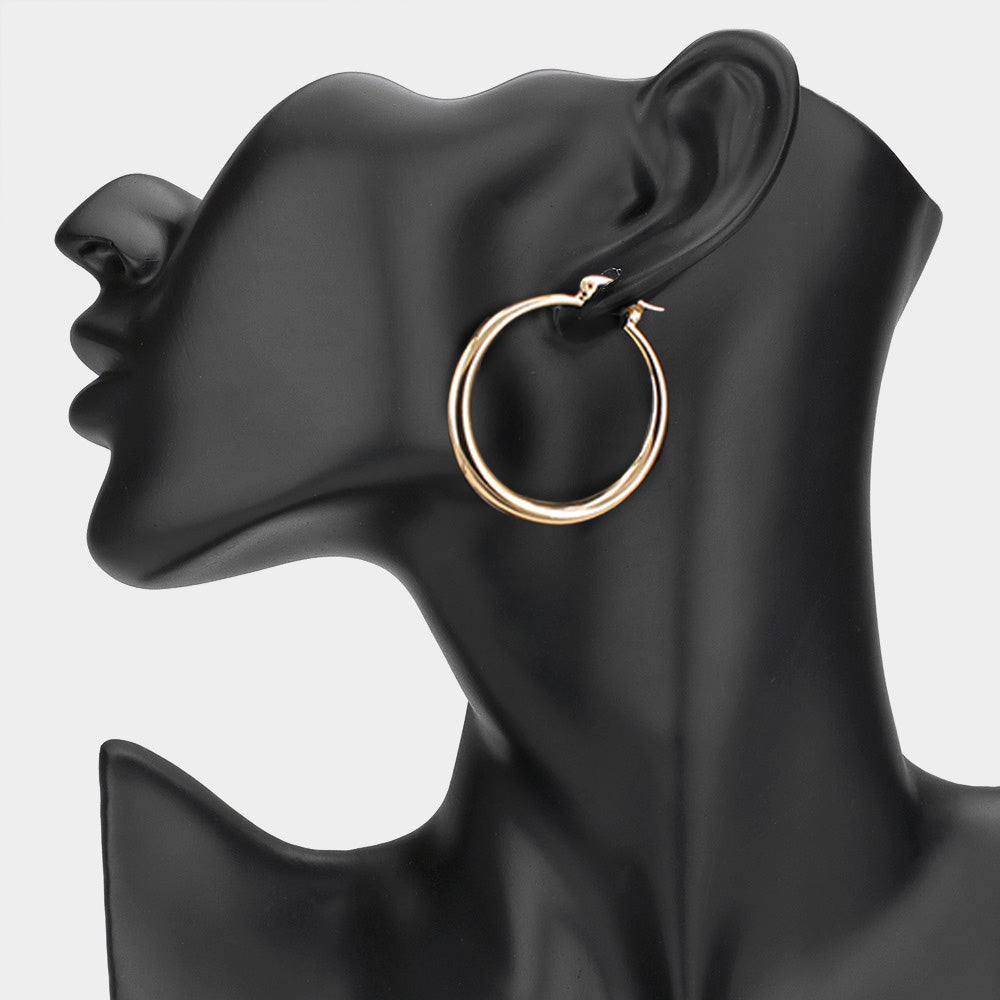 Gold 1.6-inch hoop earring with pin catch clasp, displayed on a black mannequin ear. 