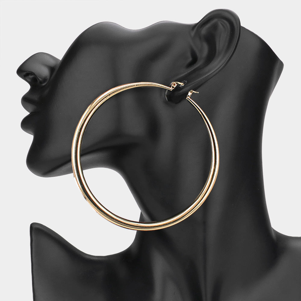 Large gold 3.25-inch hoop earring with pin catch clasp, displayed on a black mannequin ear.