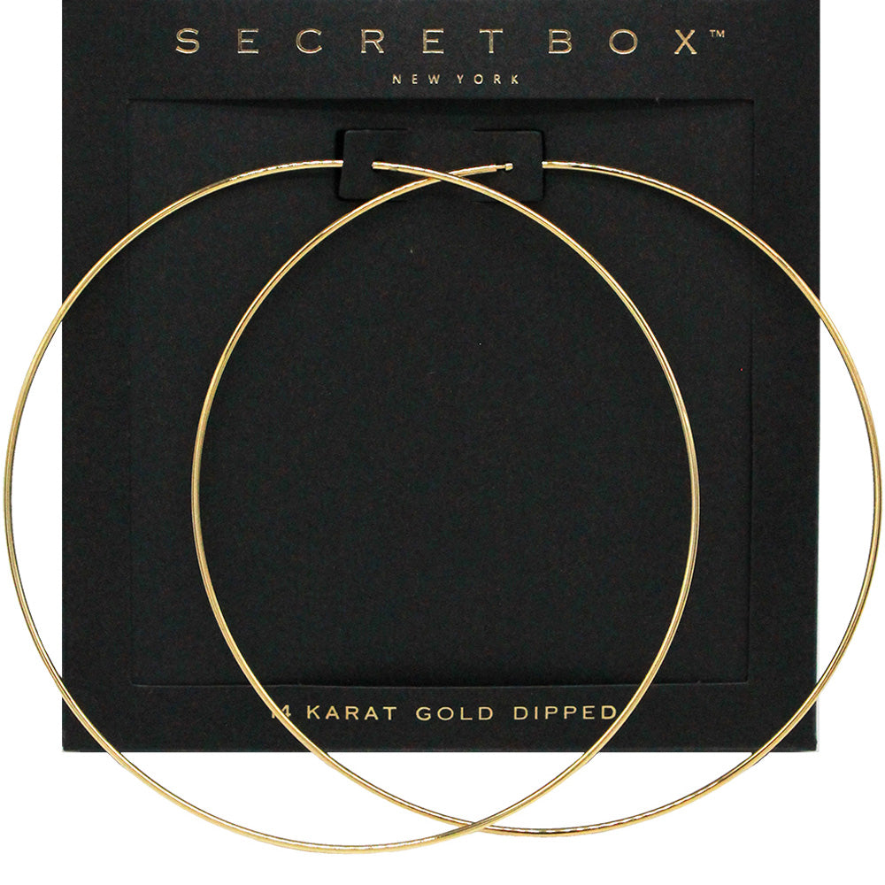 Oversized gold wire hoop earrings with a 4-inch diameter and slide-in wire closure, displayed on a black jewelry card.
