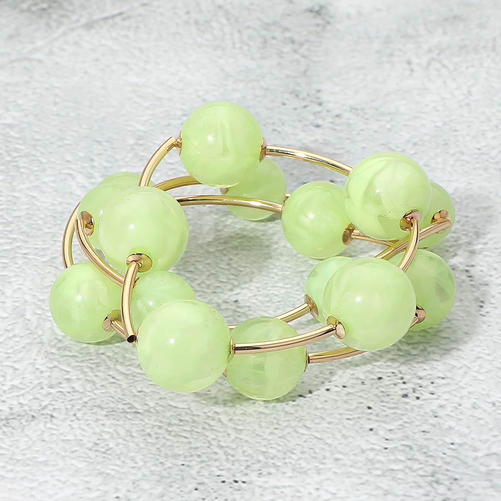 Light green chunky ball 3-piece stretch bracelet set on gold displayed on a light textured background.