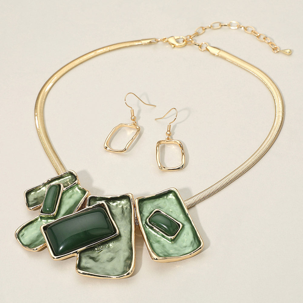 Green geometric enamel beaded necklace set with matching earrings for pageant or evening looks. It is on an ivory background.