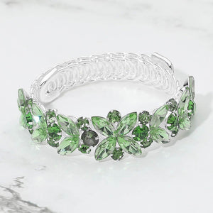 Green emerald marquise floral crystal bracelet on silver with adjustable fit, elegant statement jewelry for prom and evening wear on a marble background