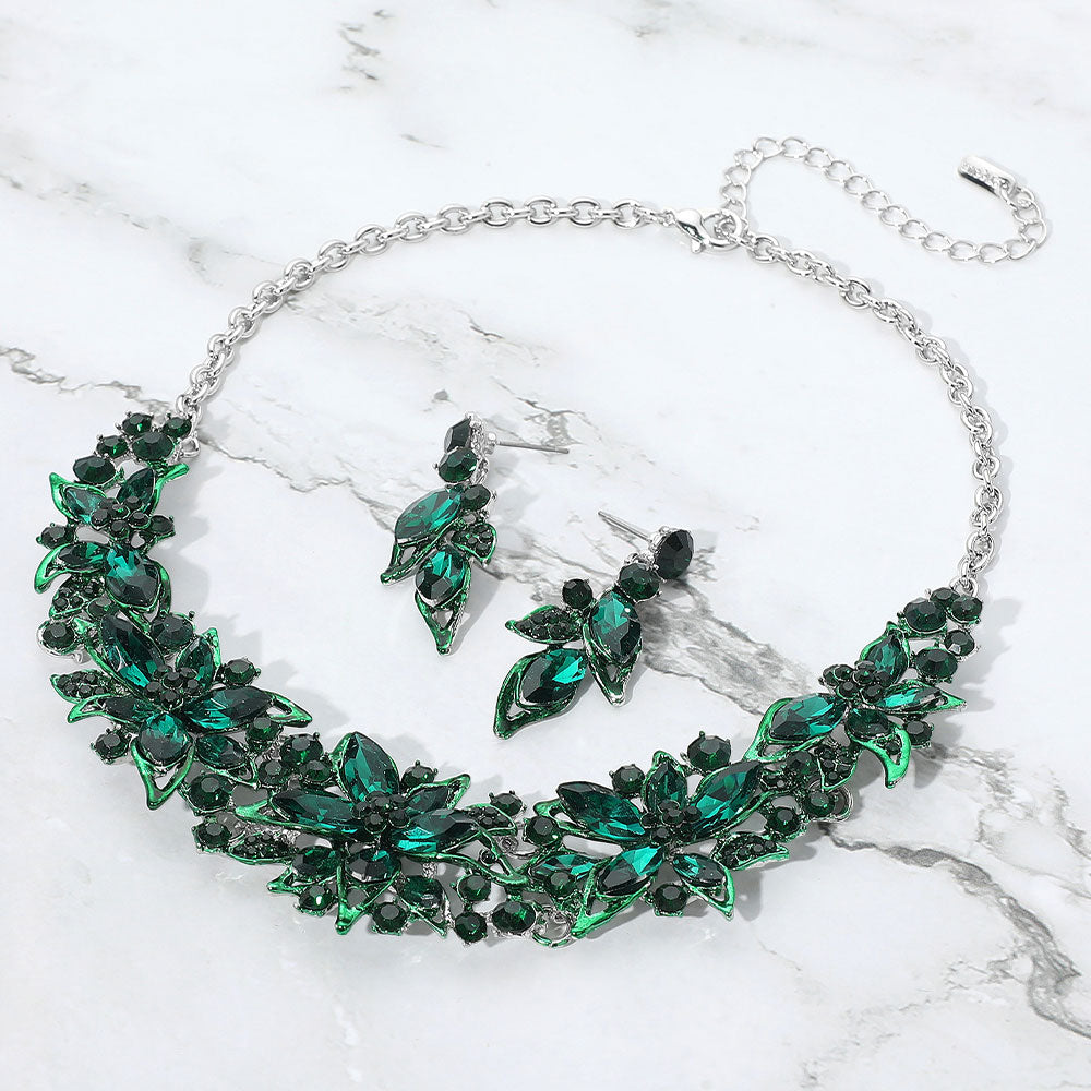 Emerald green multi shape stone collar-bib necklace set with matching drop earrings for homecoming, pageants, or formal events on a grey and white granite background
