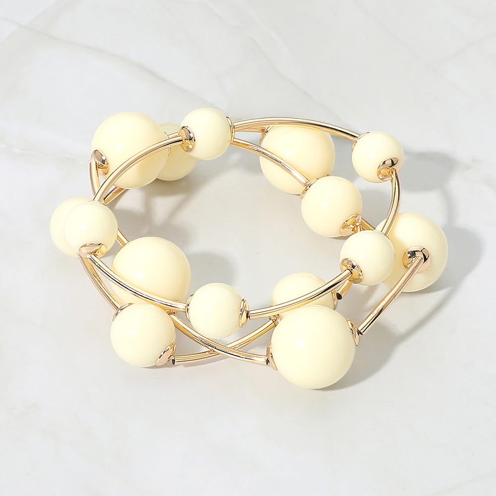 Ivory beaded stackable stretch bracelet set on gold on white marble background