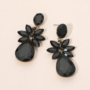 Jet Black crystal flower teardrop earrings on gold displayed on a beige background