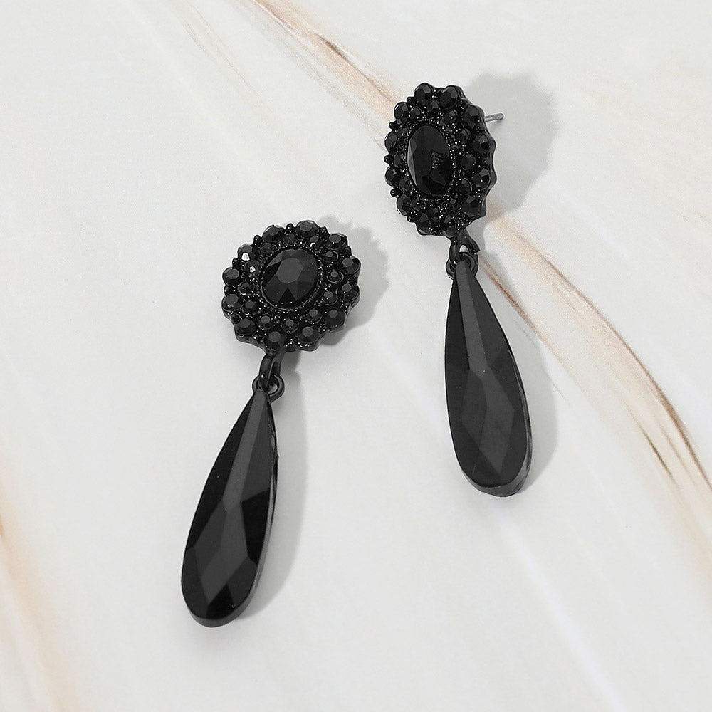 Jet black crystal halo long teardrop dangle earrings on black on a white marble background