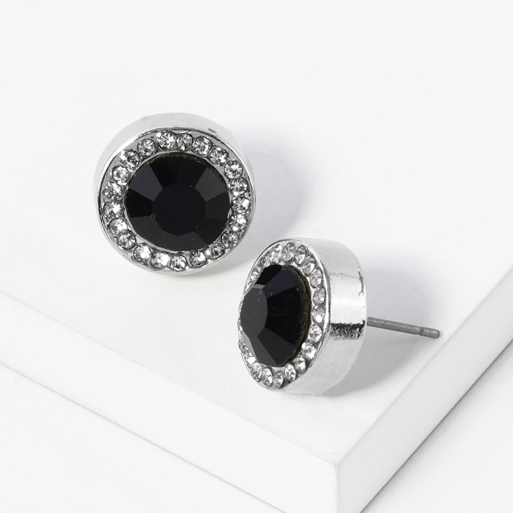 A pair of silver stud earrings with an oval black faceted center stone surrounded by a halo of small clear rhinestones, displayed on a clean white surface.