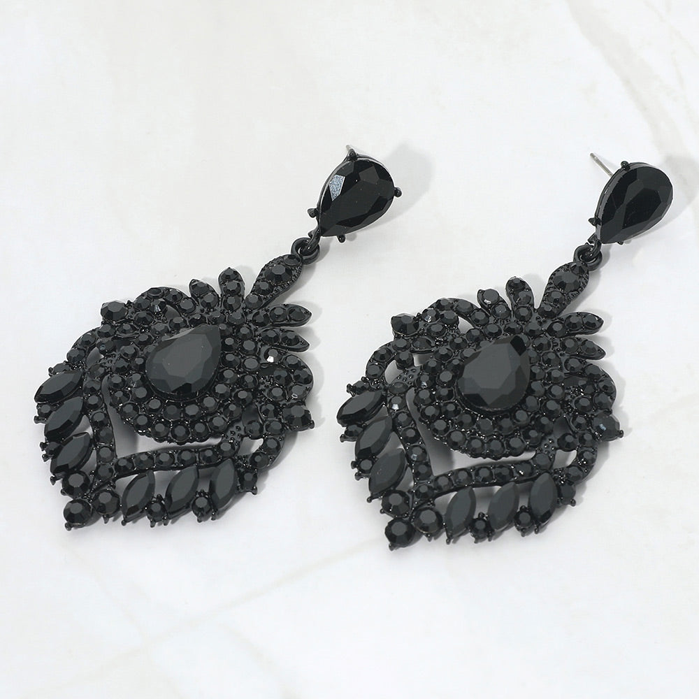 Jet Black crystal teardrop chandelier statement pageant earrings on black with an ornate layered crystal design, displayed on a white background.