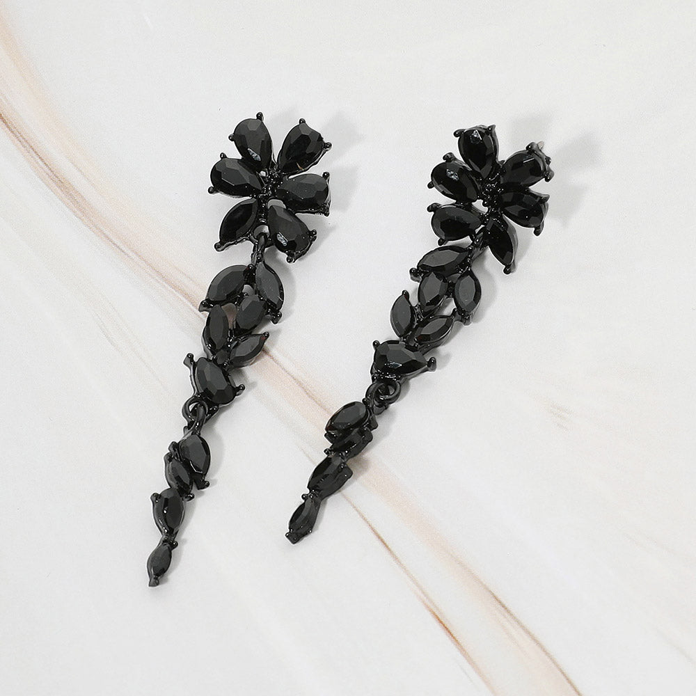 Black-tone dangle earrings featuring black marquise and round faceted crystals arranged in an elongated floral vine design, displayed on a white background.
