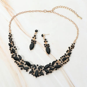 Jet Black marquise stone cluster prom and evening necklace set on gold on white marble background