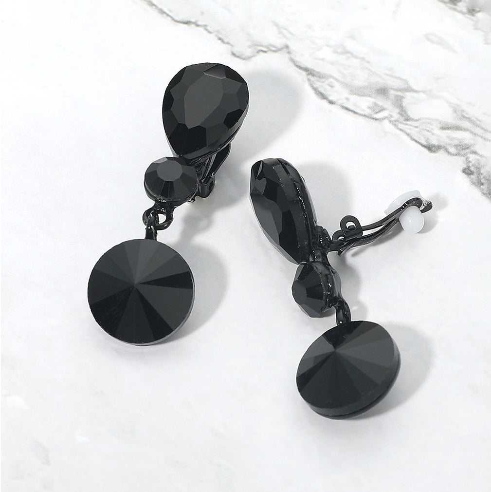 Jet black round crystal drop clip-on earrings on black on white marble background