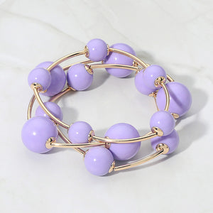 Lavender purple beaded stackable stretch bracelet set on gold on white marble background