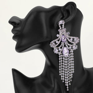 A large ornate Lavender Purple crystal statement earring on silver with cascading bead fringe and clear crystal accents on a black earring mannequin.