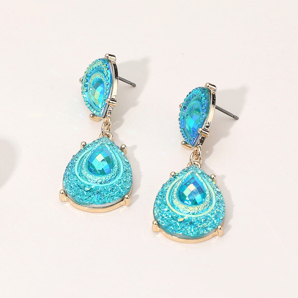 Aqua crystal glitter teardrop drop earrings on gold on light beige background