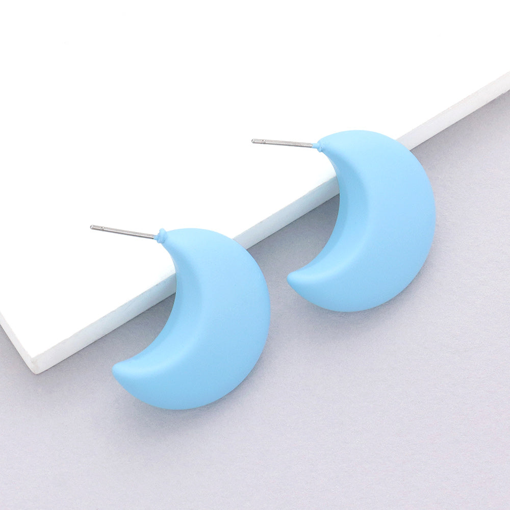 Light blue matte crescent moon earrings on a white background