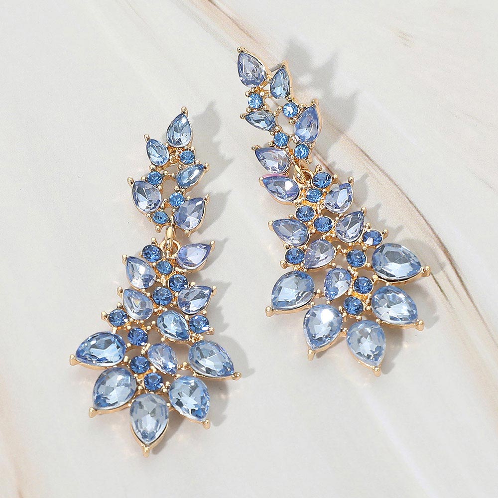 Light blue periwinkle teardrop cluster drop earrings on gold with faceted stones on white marble background