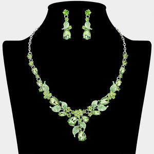 Light green teardrop leaf necklace set on silver with matching earrings for prom and evening wear on a black mannequin bust on a white background.